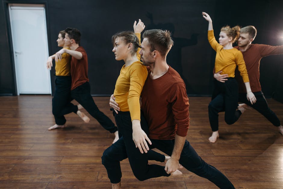 Group of dancers practicing contemporary moves in an indoor studio.