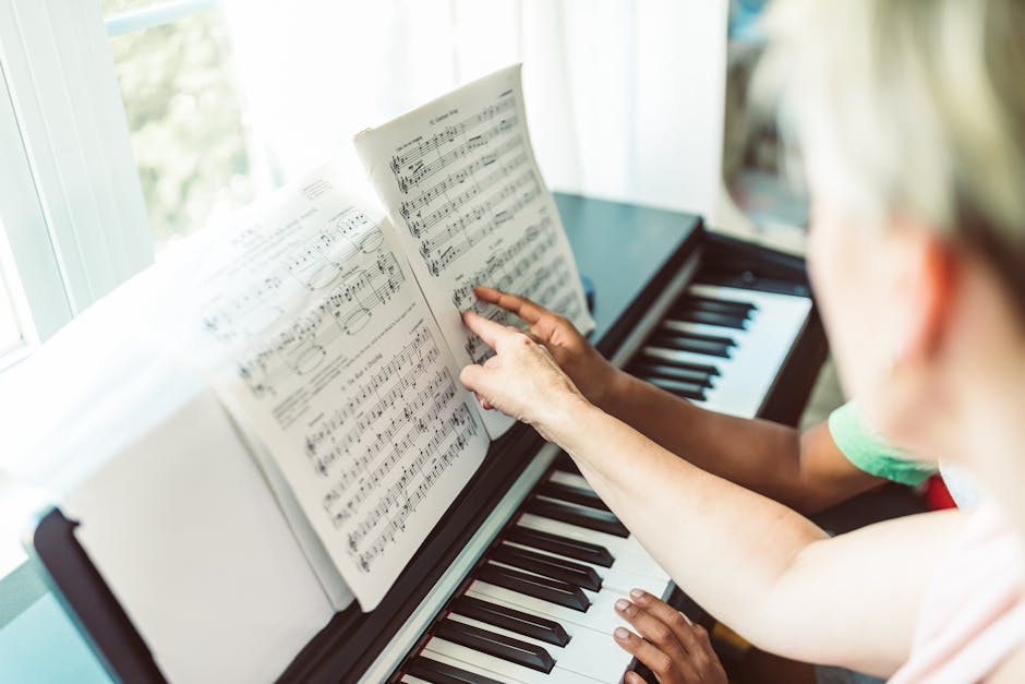 A child learning piano from an adult teacher with visible sheet music.